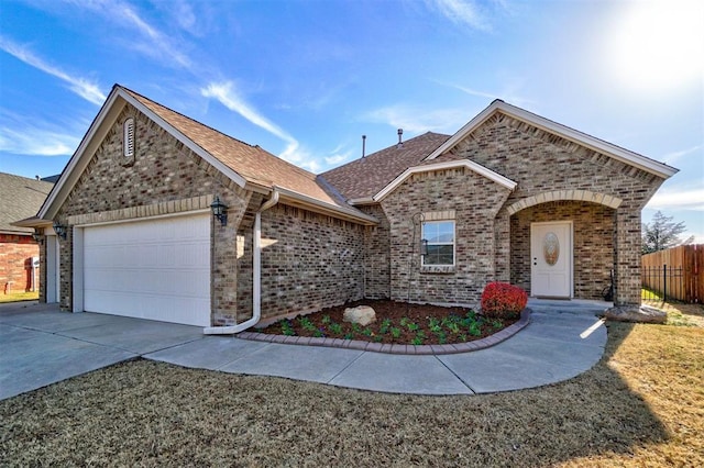 19009 Meadows Crossing Dr, Edmond, OK 73012 - view of front facade with an attached garage, brick siding, concrete driveway, and a shingled roof