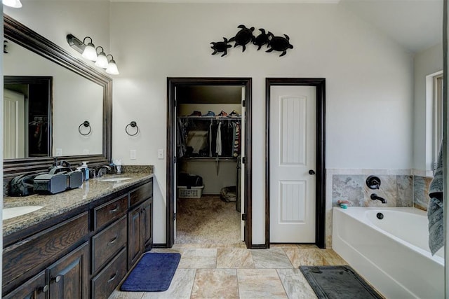 19009 Meadows Crossing Dr, Edmond, OK 73012 - bathroom featuring double vanity, a garden tub, a walk in closet, and lofted ceiling
