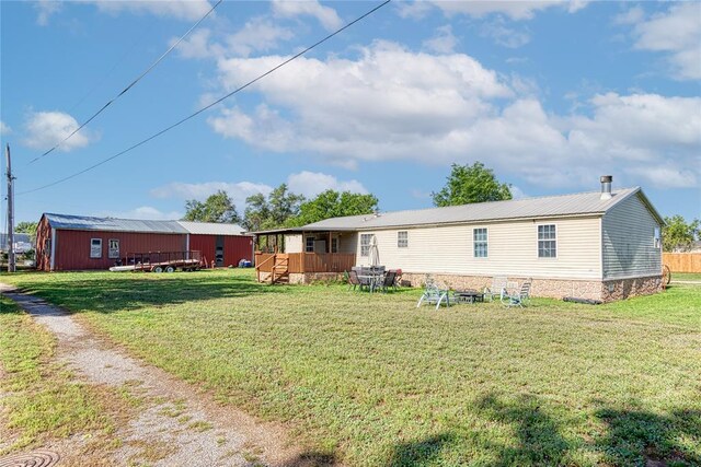 1020 S Walnut Ave, Erick, OK 73645 - back of house with a yard, a wooden deck, and an outdoor structure