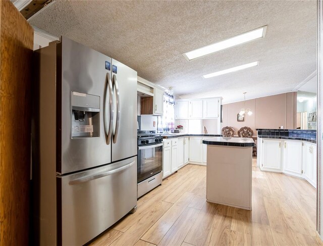 1020 S Walnut Ave, Erick, OK 73645 - kitchen with stainless steel appliances, a textured ceiling, white cabinets, light wood-type flooring, and dark countertops