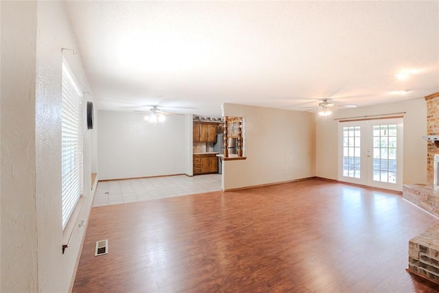 5821 NW 89th St, Oklahoma City, OK 73132 - unfurnished living room featuring ceiling fan, a brick fireplace, and light wood-type flooring