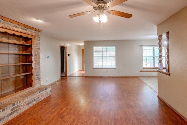 5821 NW 89th St, Oklahoma City, OK 73132 - unfurnished living room with built in features, wood finished floors, baseboards, and a ceiling fan