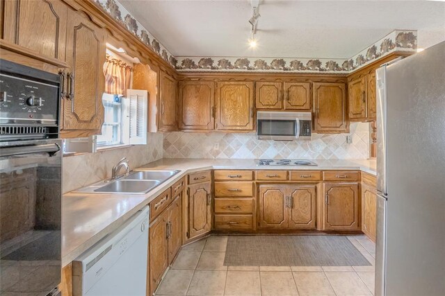 5821 NW 89th St, Oklahoma City, OK 73132 - kitchen with appliances with stainless steel finishes, a sink, brown cabinetry, and light countertops