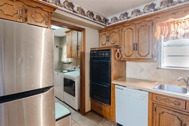 5821 NW 89th St, Oklahoma City, OK 73132 - kitchen with freestanding refrigerator, dishwasher, washing machine and clothes dryer, brown cabinets, and a textured ceiling