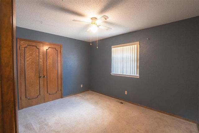 5821 NW 89th St, Oklahoma City, OK 73132 - unfurnished bedroom featuring carpet flooring, a textured ceiling, baseboards, ceiling fan, and a closet