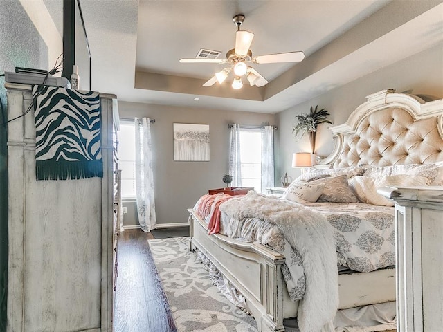 4508 Applegate Dr, Moore, OK 73160 - bedroom featuring wood finished floors, a tray ceiling, baseboards, and ceiling fan
