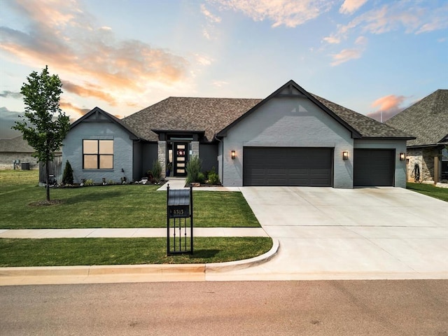 4315 Dusty Trl, Norman, OK 73072 - view of front of home featuring a garage, a lawn, concrete driveway, brick siding, and a shingled roof