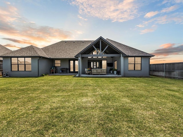 4315 Dusty Trl, Norman, OK 73072 - back of house at dusk featuring roof with shingles, a patio area, and brick siding