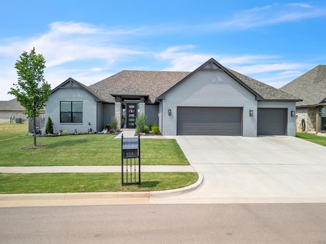 4315 Dusty Trl, Norman, OK 73072 - view of front of house with an attached garage, a front lawn, concrete driveway, and roof with shingles