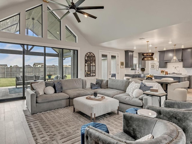 4315 Dusty Trl, Norman, OK 73072 - living room with high vaulted ceiling, light wood-type flooring, recessed lighting, ceiling fan, and a chandelier