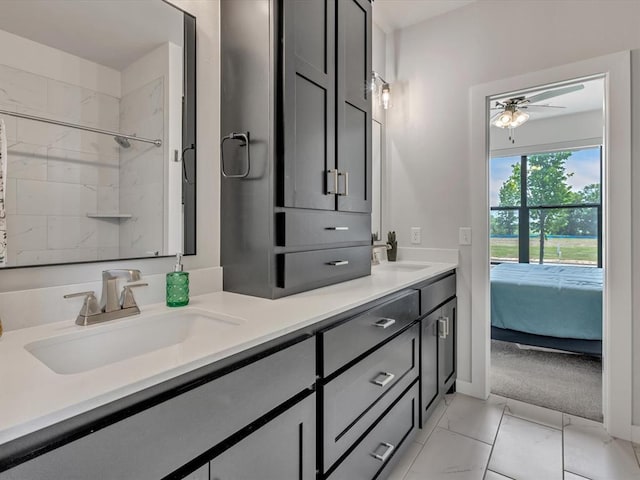 4315 Dusty Trl, Norman, OK 73072 - ensuite bathroom featuring double vanity, ceiling fan, marble look tiles, and baseboards