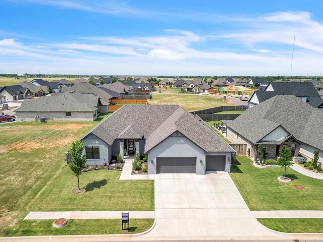 4315 Dusty Trl, Norman, OK 73072 - view of front facade featuring a residential view, an attached garage, concrete driveway, a shingled roof, and a front lawn