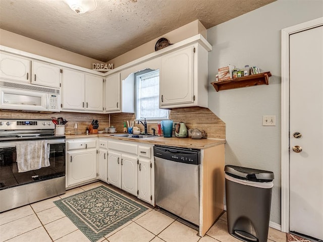 11379 Kirkwin Ln, Choctaw, OK 73020 - kitchen with appliances with stainless steel finishes, a sink, decorative backsplash, light countertops, and white cabinets