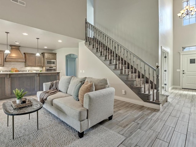 10740 Starboard Way, Edmond, OK 73025 - living area featuring a towering ceiling, stairs, wood finish floors, recessed lighting, and arched walkways