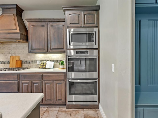 10740 Starboard Way, Edmond, OK 73025 - kitchen with appliances with stainless steel finishes, premium range hood, light countertops, and tasteful backsplash