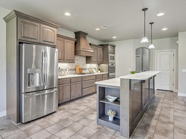 10740 Starboard Way, Edmond, OK 73025 - kitchen with stainless steel appliances, custom range hood, open shelves, tasteful backsplash, and light countertops