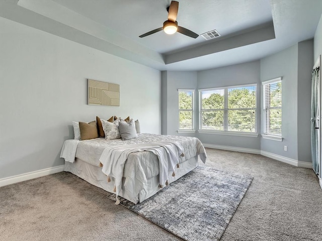 10740 Starboard Way, Edmond, OK 73025 - carpeted bedroom with a tray ceiling and a ceiling fan