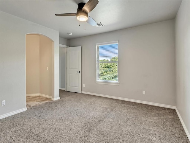 10740 Starboard Way, Edmond, OK 73025 - unfurnished bedroom featuring carpet floors, arched walkways, and a ceiling fan