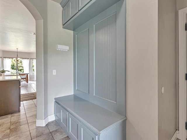 10740 Starboard Way, Edmond, OK 73025 - mudroom featuring arched walkways, light tile patterned flooring, and a chandelier