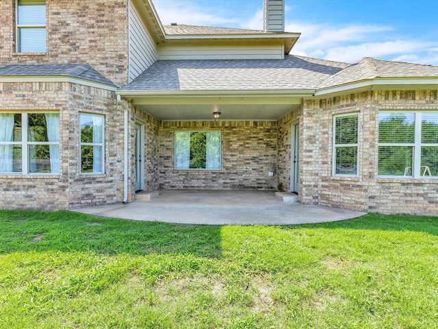 10740 Starboard Way, Edmond, OK 73025 - rear view of house with a patio, a chimney, a lawn, and brick siding