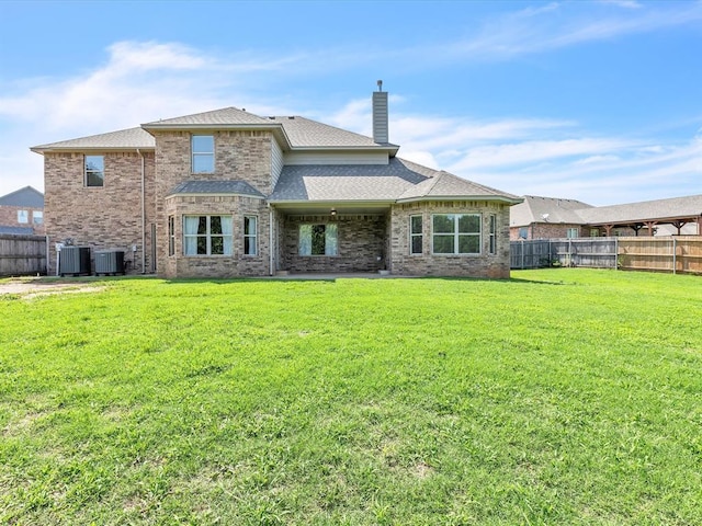 10740 Starboard Way, Edmond, OK 73025 - rear view of property with a chimney, a fenced backyard, a shingled roof, and brick siding
