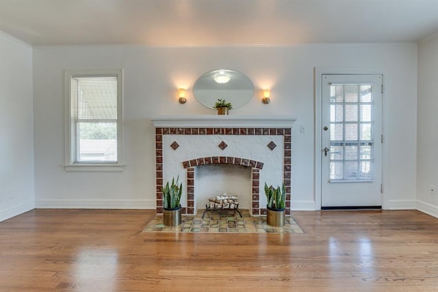 1502 NW 39th St, Oklahoma City, OK 73118 - living area featuring crown molding, wood finished floors, plenty of natural light, a brick fireplace, and baseboards