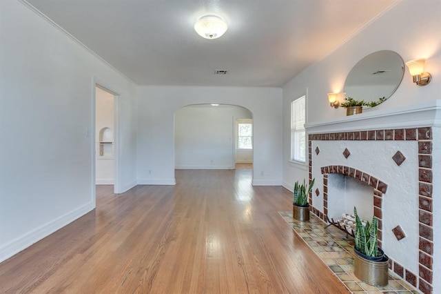 1502 NW 39th St, Oklahoma City, OK 73118 - unfurnished living room featuring arched walkways, wood finished floors, a fireplace, baseboards, and ornamental molding