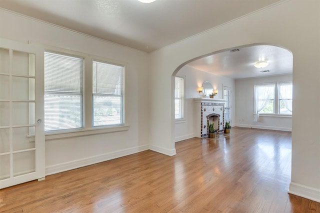 1502 NW 39th St, Oklahoma City, OK 73118 - living room featuring arched walkways, baseboards, wood finished floors, crown molding, and a brick fireplace