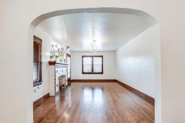 1502 NW 39th St, Oklahoma City, OK 73118 - unfurnished living room featuring wood-type flooring, a chandelier, a fireplace, and baseboards