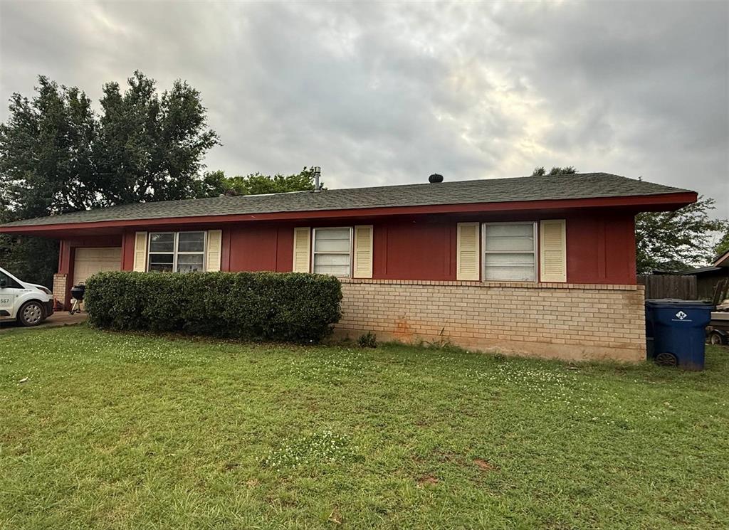 329 Milky Way, Guthrie, OK 73044 - view of home's exterior with a garage, brick siding, a lawn, and a shingled roof