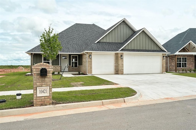 10421 SW 50th St, Mustang, OK 73064 - craftsman-style home with board and batten siding, an attached garage, a front lawn, concrete driveway, and brick siding