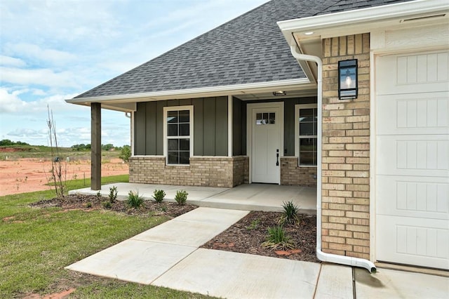 10421 SW 50th St, Mustang, OK 73064 - entrance to property with roof with shingles, board and batten siding, covered porch, brick siding, and a yard