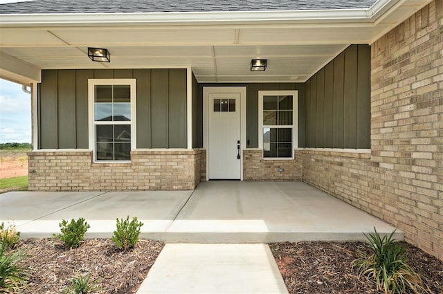 10421 SW 50th St, Mustang, OK 73064 - property entrance with roof with shingles, board and batten siding, and brick siding