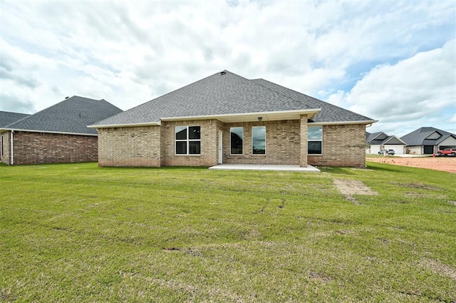 10421 SW 50th St, Mustang, OK 73064 - back of house featuring a patio, roof with shingles, brick siding, and a lawn
