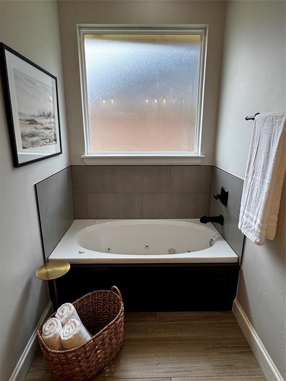 10421 SW 50th St, Mustang, OK 73064 - full bathroom featuring a jetted tub and wood finished floors