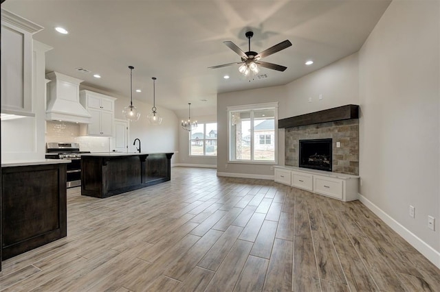 10440 SW 50th St, Mustang, OK 73064 - kitchen with gas stove, custom exhaust hood, open floor plan, light countertops, and recessed lighting