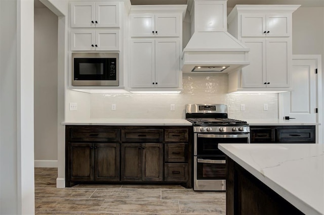 10440 SW 50th St, Mustang, OK 73064 - kitchen with custom range hood, stainless steel appliances, and white cabinetry