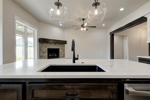 10440 SW 50th St, Mustang, OK 73064 - kitchen with a sink, a stone fireplace, open floor plan, a ceiling fan, and stainless steel dishwasher