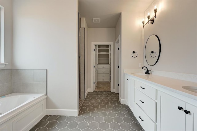 10440 SW 50th St, Mustang, OK 73064 - full bath with double vanity, a garden tub, a walk in closet, tile patterned flooring, and baseboards