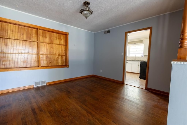 3701 NW 18th St, Oklahoma City, OK 73107 - spare room featuring wood finished floors, a sink, baseboards, a textured ceiling, and crown molding