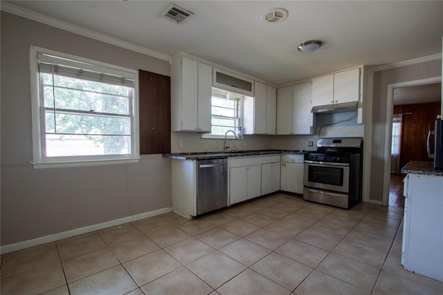 3701 NW 18th St, Oklahoma City, OK 73107 - kitchen with stainless steel appliances, under cabinet range hood, ornamental molding, backsplash, and white cabinets