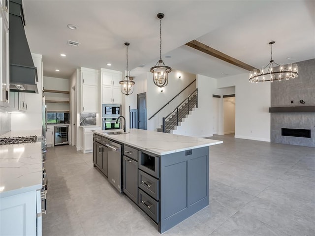 1116 Gateway Bridge Rd, Edmond, OK 73034 - kitchen with wine cooler, stainless steel appliances, a chandelier, custom exhaust hood, and recessed lighting