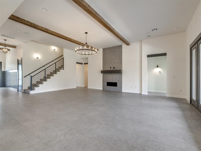 1116 Gateway Bridge Rd, Edmond, OK 73034 - unfurnished living room featuring beam ceiling, a fireplace, a chandelier, stairway, and baseboards
