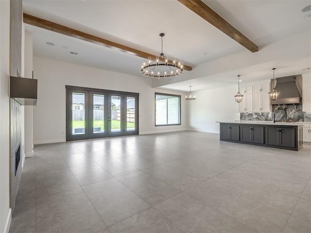 1116 Gateway Bridge Rd, Edmond, OK 73034 - unfurnished living room featuring beam ceiling, a chandelier, baseboards, french doors, and light tile patterned floors