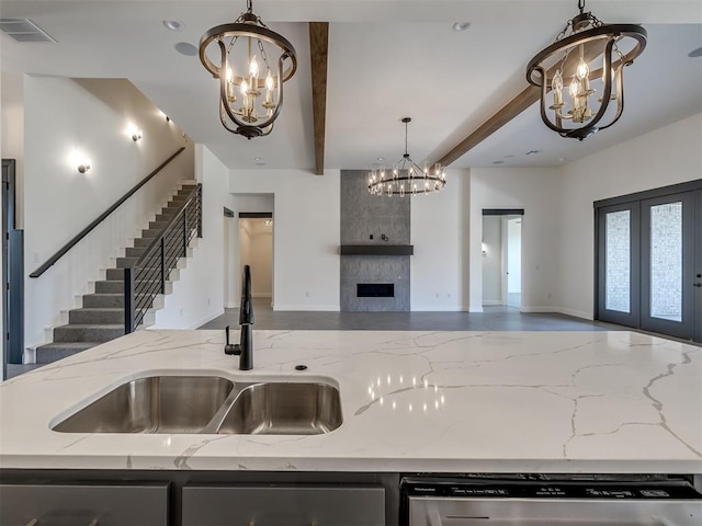 1116 Gateway Bridge Rd, Edmond, OK 73034 - kitchen with a chandelier, open floor plan, a sink, dishwasher, and a fireplace