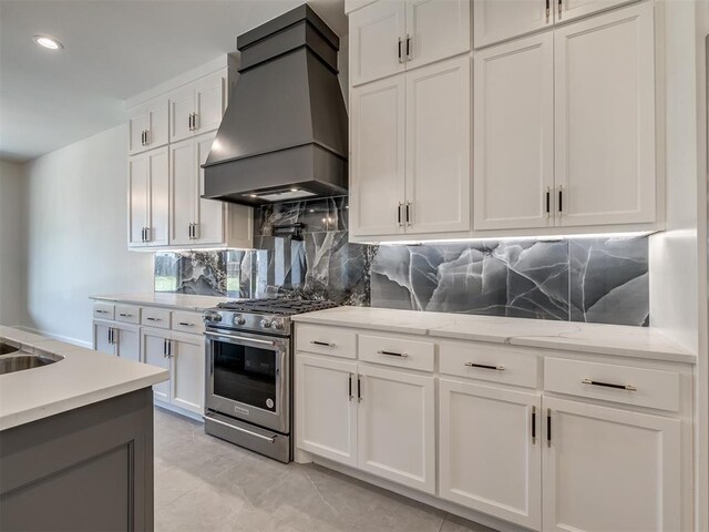 1116 Gateway Bridge Rd, Edmond, OK 73034 - kitchen featuring premium range hood, stainless steel gas range oven, tasteful backsplash, white cabinetry, and light stone counters