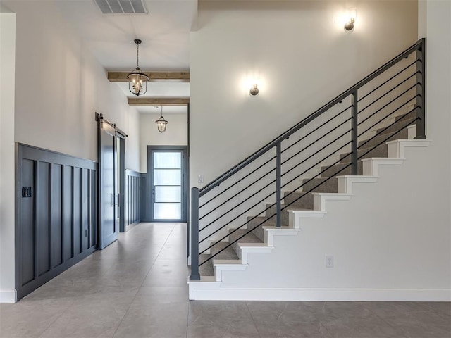 1116 Gateway Bridge Rd, Edmond, OK 73034 - staircase featuring a high ceiling, a barn door, and beam ceiling