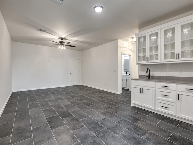 1116 Gateway Bridge Rd, Edmond, OK 73034 - spare room featuring a sink, ceiling fan, dark tile patterned flooring, and baseboards