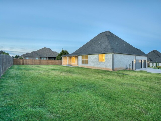 1116 Gateway Bridge Rd, Edmond, OK 73034 - rear view of house with a shingled roof, brick siding, driveway, and a garage