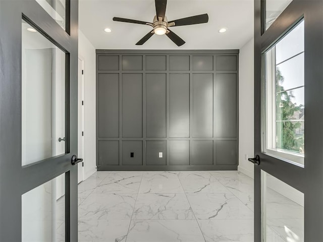 1117 Falls Bridge Ct, Edmond, OK 73034 - unfurnished room with light marble finish floors, ceiling fan, recessed lighting, a decorative wall, and baseboards